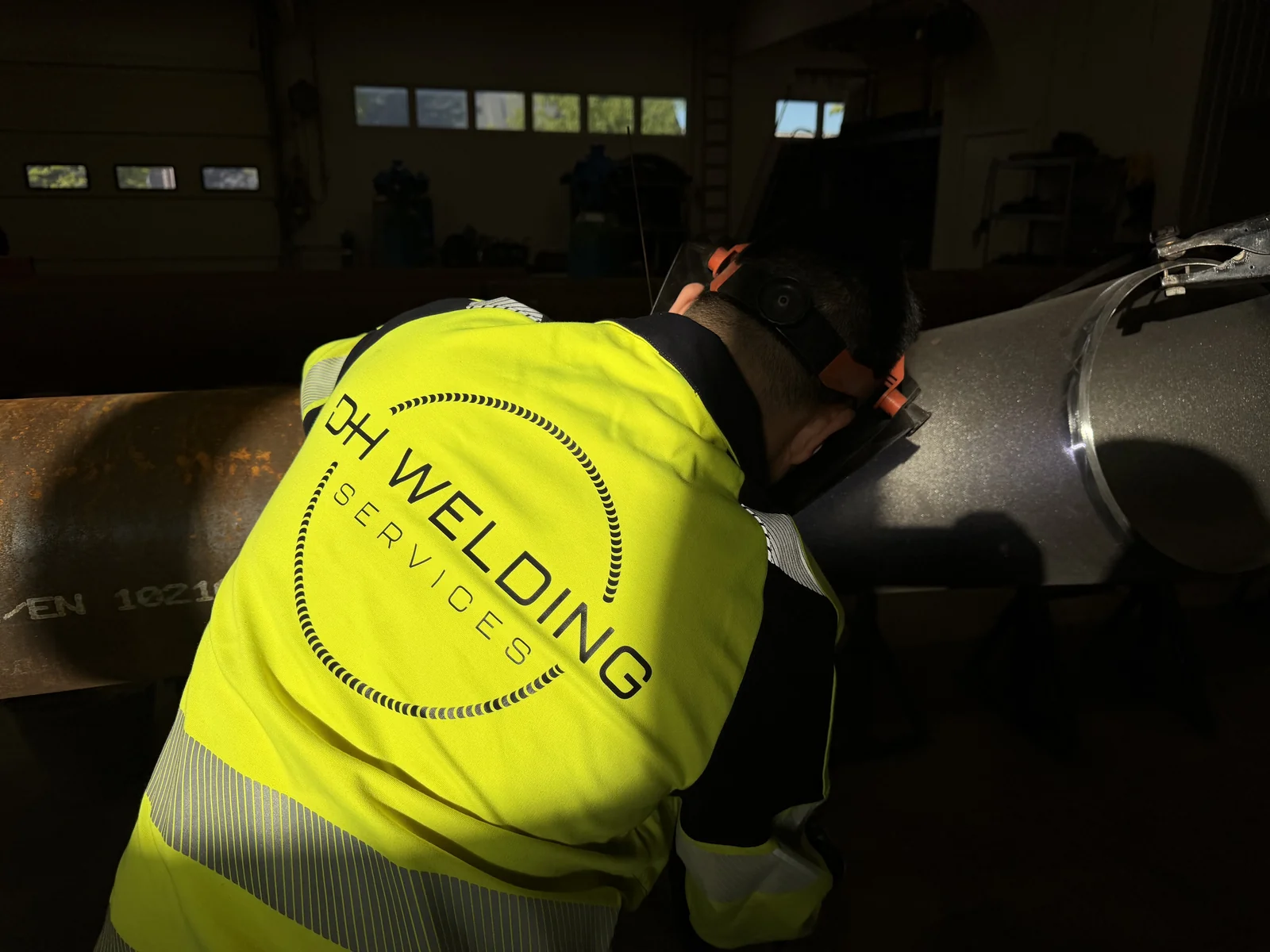 Zvárač DH Welding Services pri kontrole zvarového spoja na oceľovom potrubí
